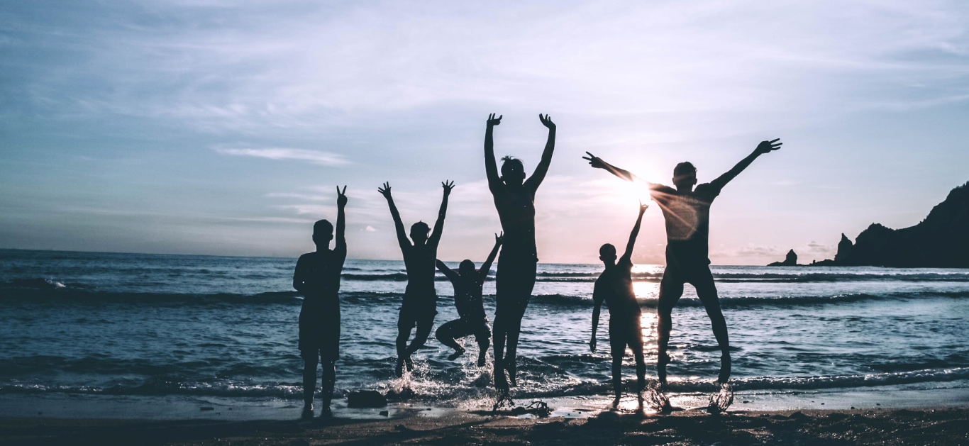 People enjoying sunset on beach.