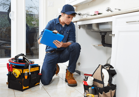 Plumbing Plumber looking under the sink