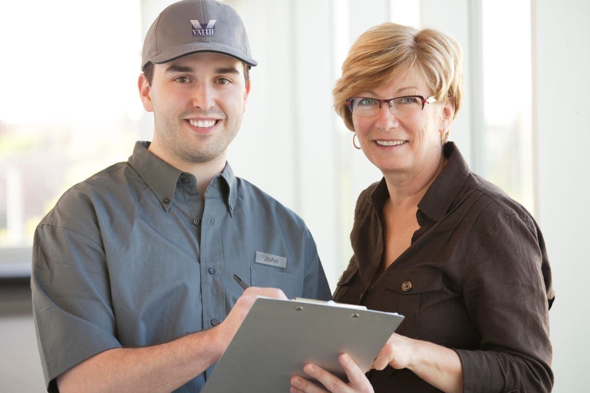 HVAC service technician talking to customer.
