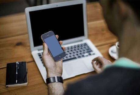 Male employee checking phone, remote work